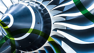 Nahaufnahme einer Flugzeugturbine und durch grafische Nachbearbeitung darübergelegt die grünen gebogenen Linien aus dem Logo von PtXLab Lausitz