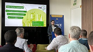 Lukas Hormdasch vom PtX Lab Lausitz hält einen Vortrag auf der EUBCE 2025 in Valencia. Die Leinwand zeigt die „Take home message“ seiner Präsentation. Im Vordergrund sind die Hinterköpfe der Zuhörenden zu sehen.