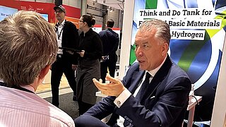 Two people in conversation at an exhibition booth.