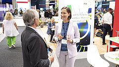 Zwei Personen unterhalten sich auf einer Messe.