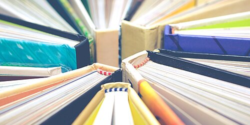 Eine Vielzahl von bunten Publikationen stehen in einem Kreis zusammen.