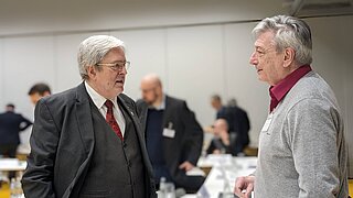 Zwei Männer unterhalten sich in einem Konferenzraum