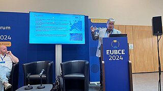 Ein Mann steht auf einer Bühne und hält einen Vortrag