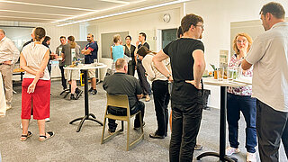 People in a room, round tables.