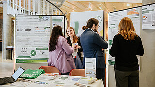 Mitarbeitende und Interessierte unterhalten sich am PtX Lab Lausitz Konferenzstand