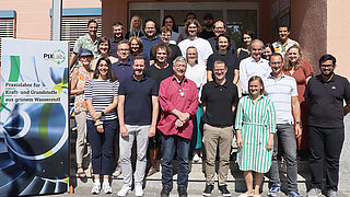 Photo shows employees of the PtX Lab Lausitz with the head of the climate protection and transport department at the BMWK in front of an office building in Cottbus.