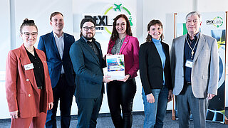 A group of people present a study. The PtX Lab Lausitz logo can be seen in the background.