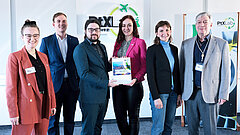 Gruppe von Personen präsentieren eine Studie. Im Hintergrund ist das Logo des PtX Lab Lausitz.