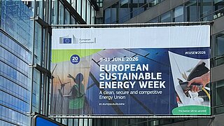 Poster über dem Eingang zur EUSEW 2026 mit dem Vollständigen Titel, im Vordergrund der Schild zur Metro und ein Lastenfahrrad