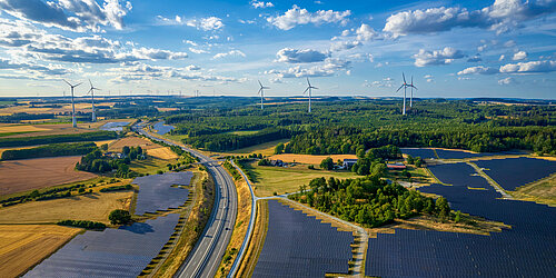Solarpark und Windkraftanlagen in der Nähe der Autobahnkreuzung