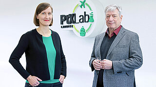 Foto von Anita Demuth und Dr. Harry Lehmann. Im Hintergrund Logo des PtX Lab Lausitz.