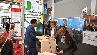 Zwei interessierte Männer informieren sich an einem Messestand