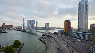 Ansicht von Rotterdam: im Vordergrund ein Fluss, im Hintergrund Hochhäuser
