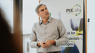 Mann steht vor einem Roll-Up des PtX Lab Lausitz.