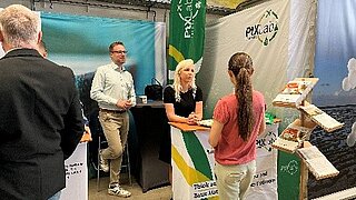 The PtX Lab Lausitz team in conversation with a visitor at Decarbon Days 2025