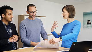 Three persons are discussing.